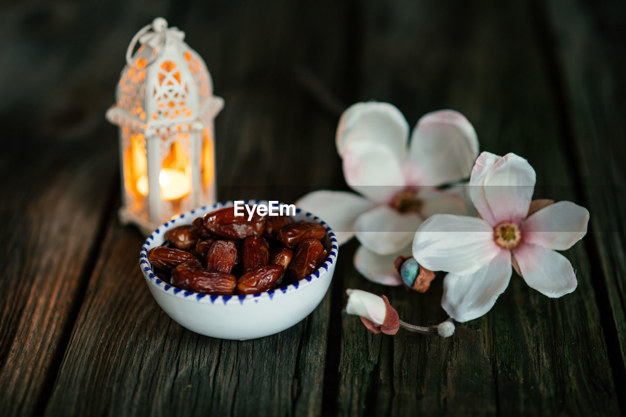 food and drink, food, freshness, sweet food, flower, sweet, dessert, wood, flowering plant, plant, cake, nature, baked, no people, table, candle, beauty in nature, celebration, indoors, sweetness, icing, studio shot, close-up, still life, temptation, fruit, dark