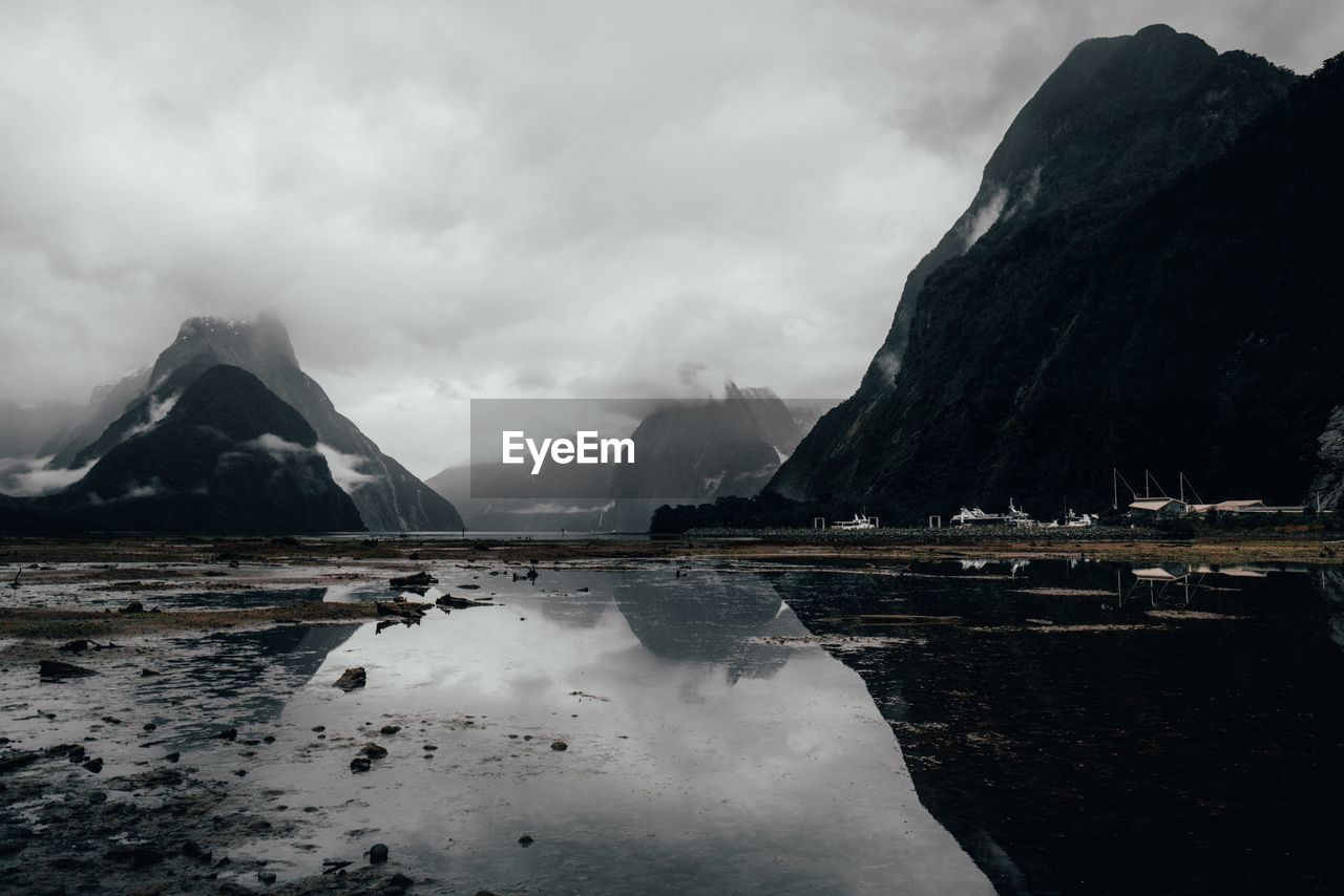 Scenic view of lake by snowcapped mountains against sky