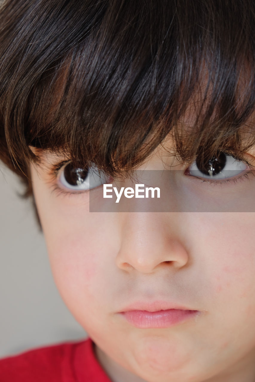 Close-up of young cute boy with eyes wide open and looking away from camera.