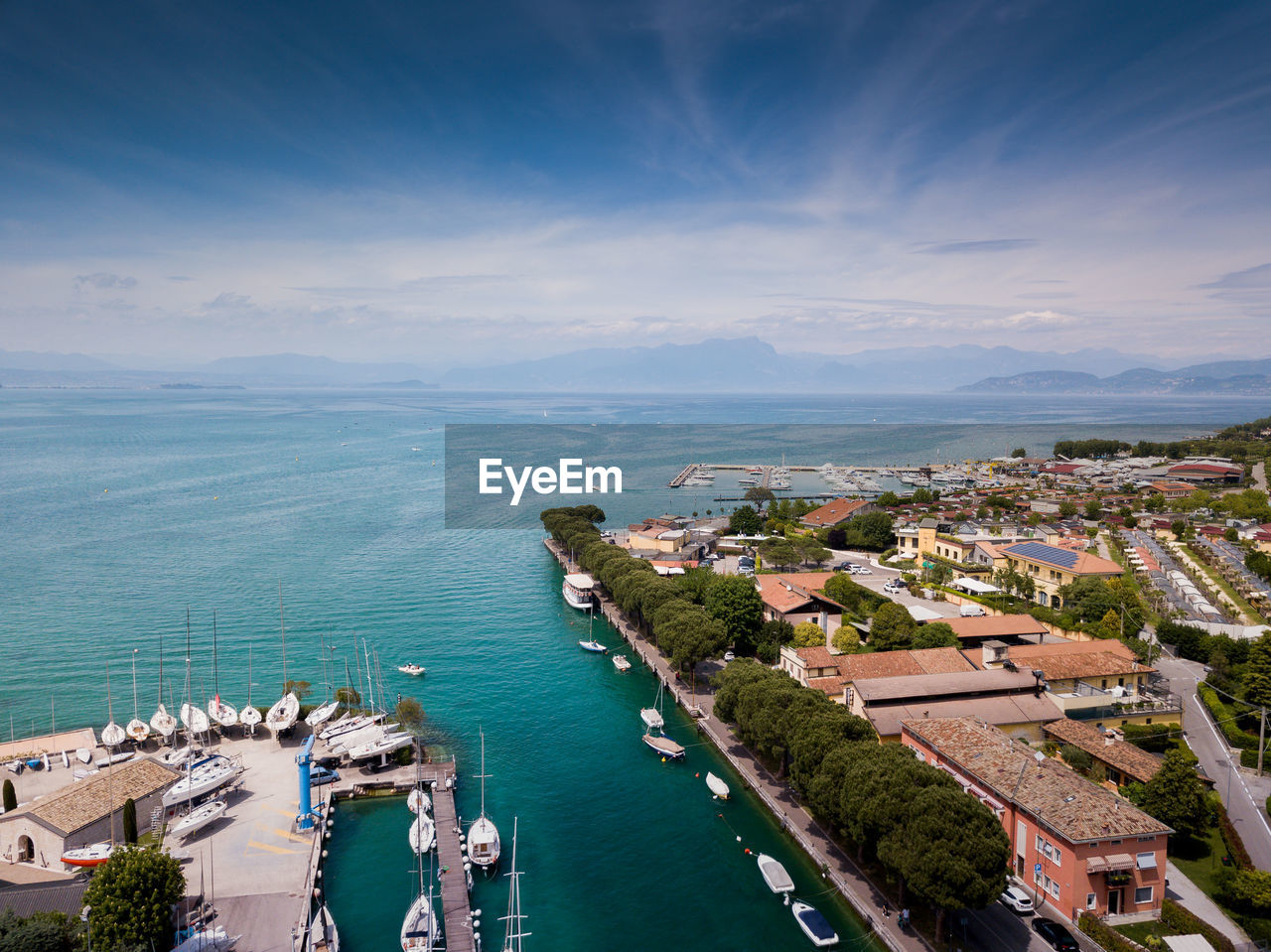 High angle view of city by sea against sky