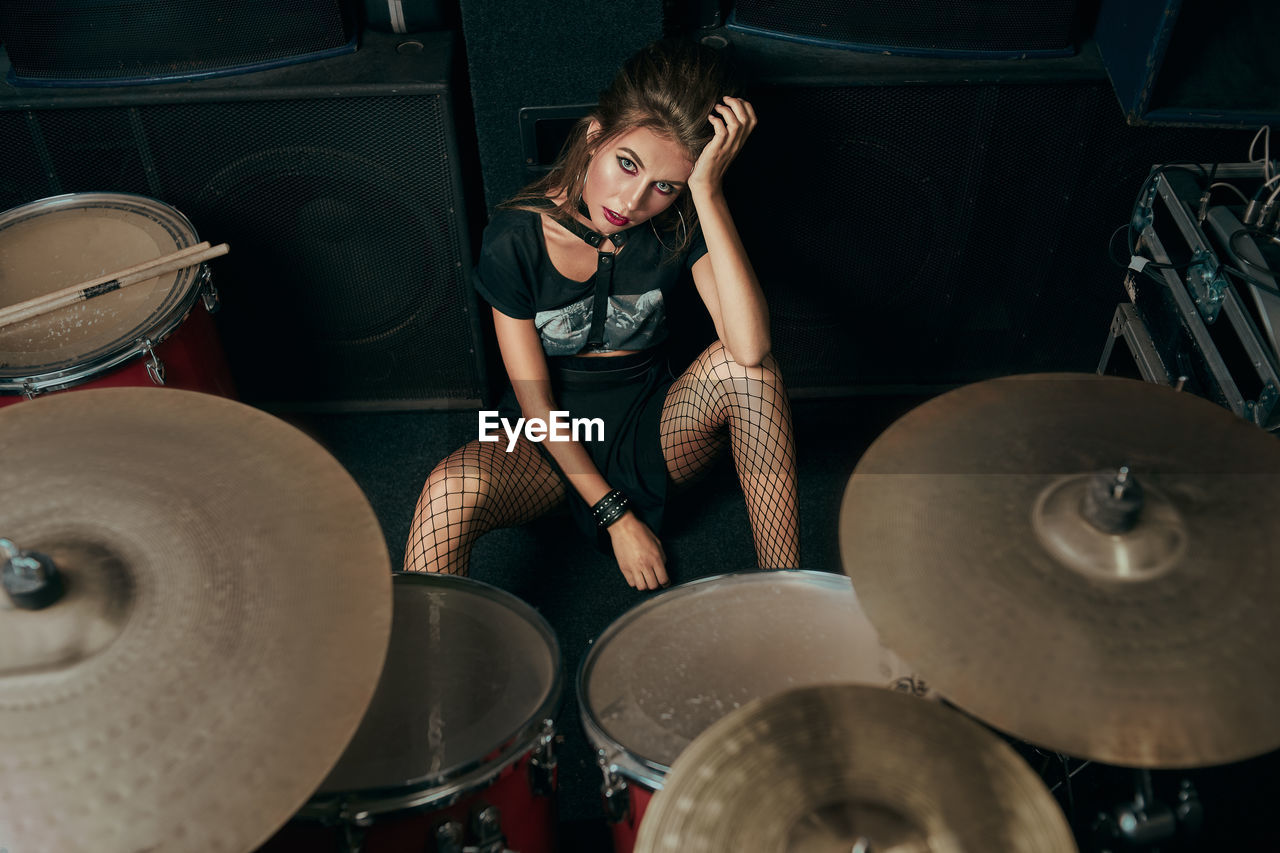 Portrait of young woman sitting on stage