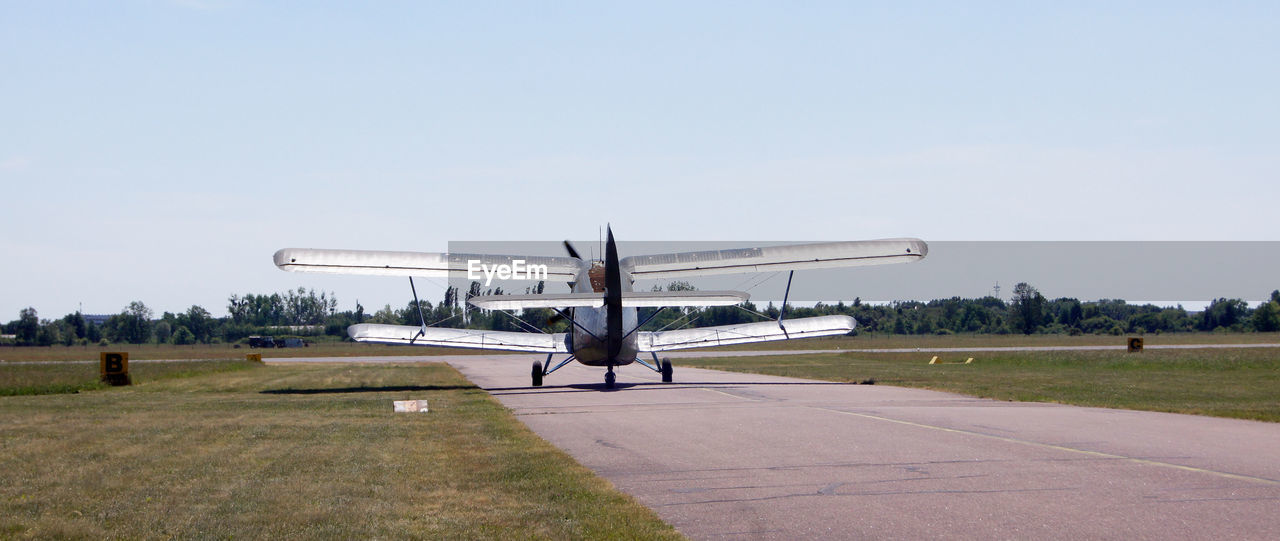 AIRPLANE ON RUNWAY AGAINST CLEAR SKY