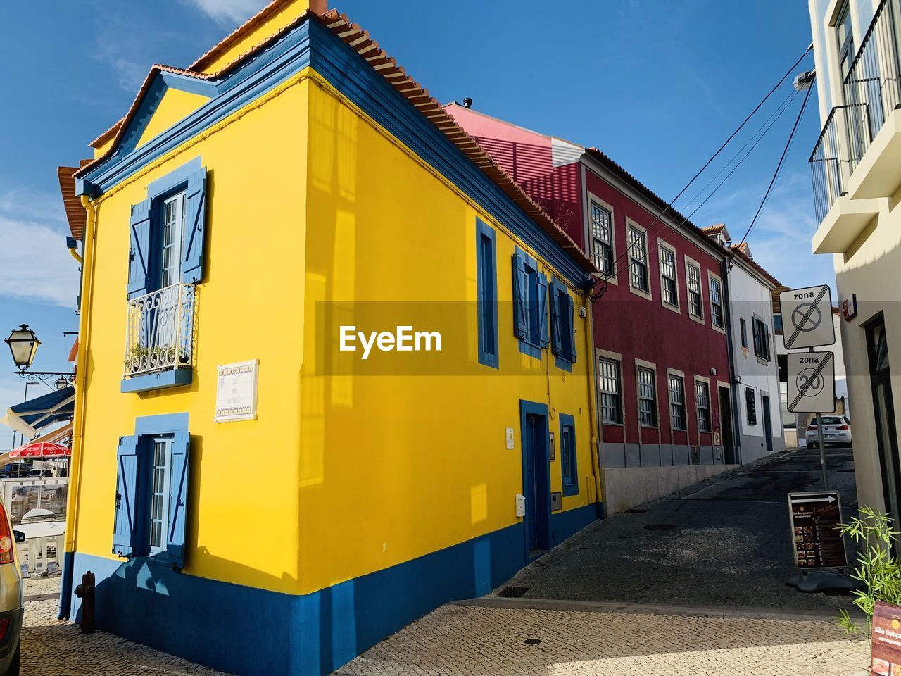 Yellow street amidst buildings against sky