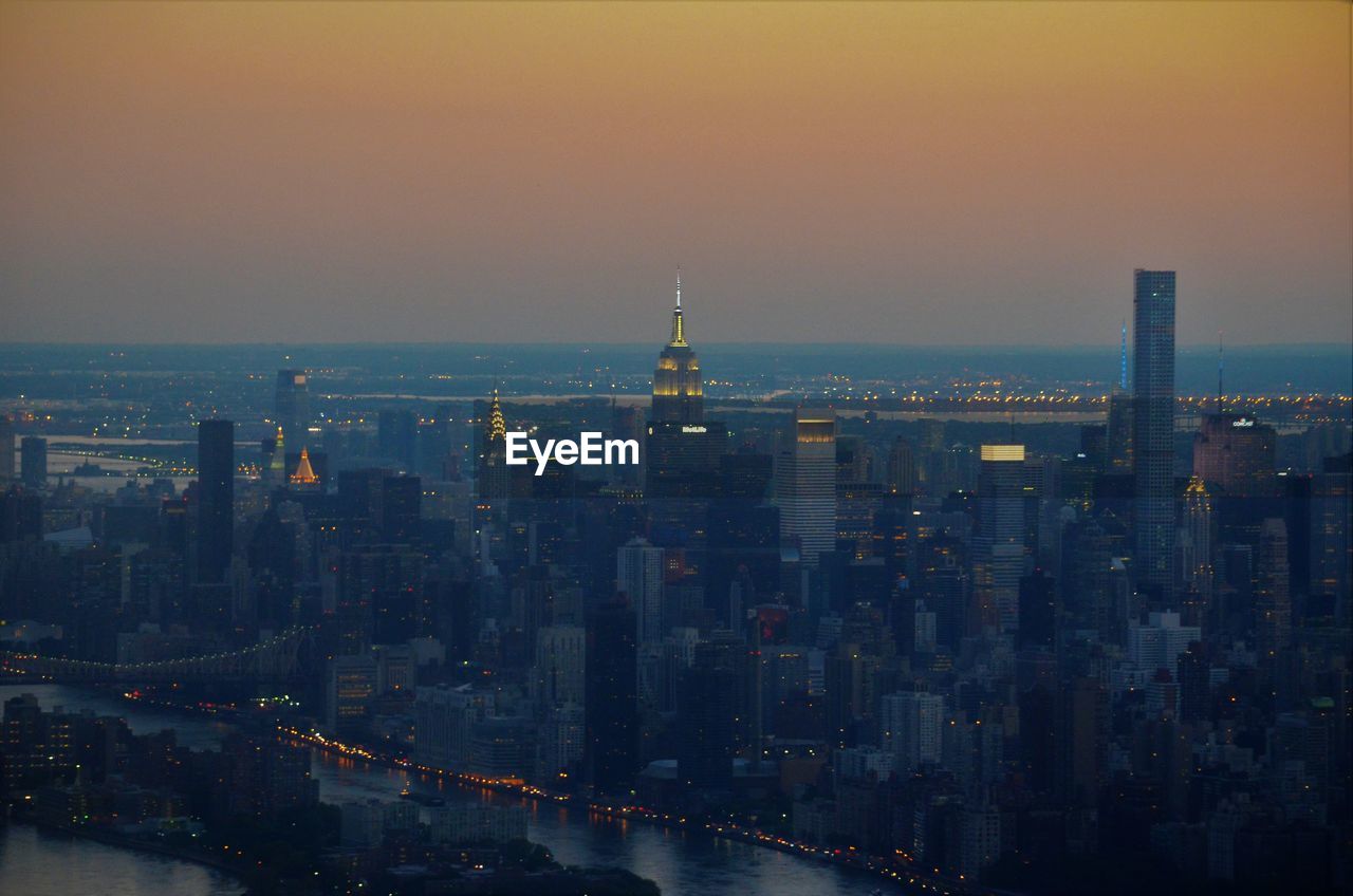 Aerial view of city lit up at sunset