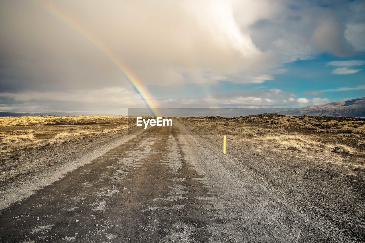 Scenic view of rainbow over road against sky