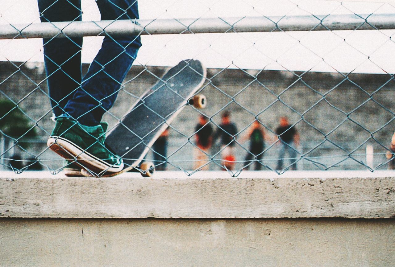 Low section of man with skateboard standing on wall