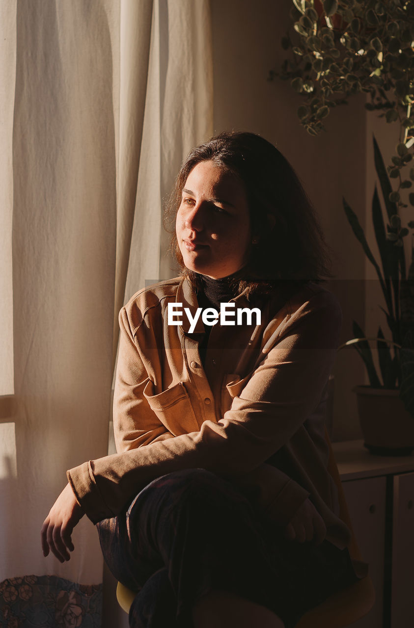 Midsection of woman sitting at home