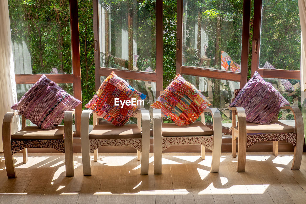 EMPTY CHAIRS AND TABLE AGAINST WINDOW