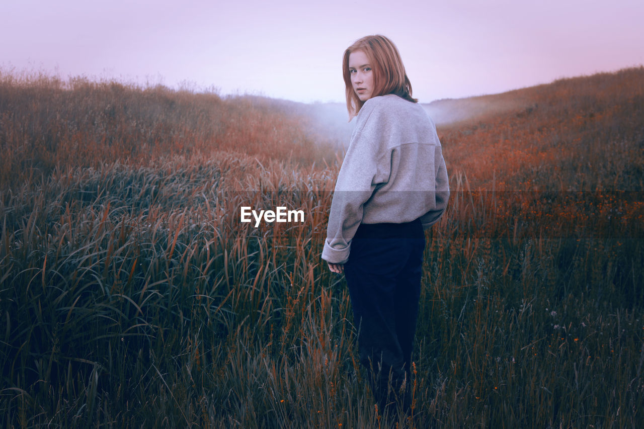 Portrait of teenage girl standing by plants