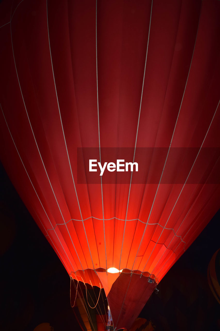 Illuminated orange hot air balloon at dusk
