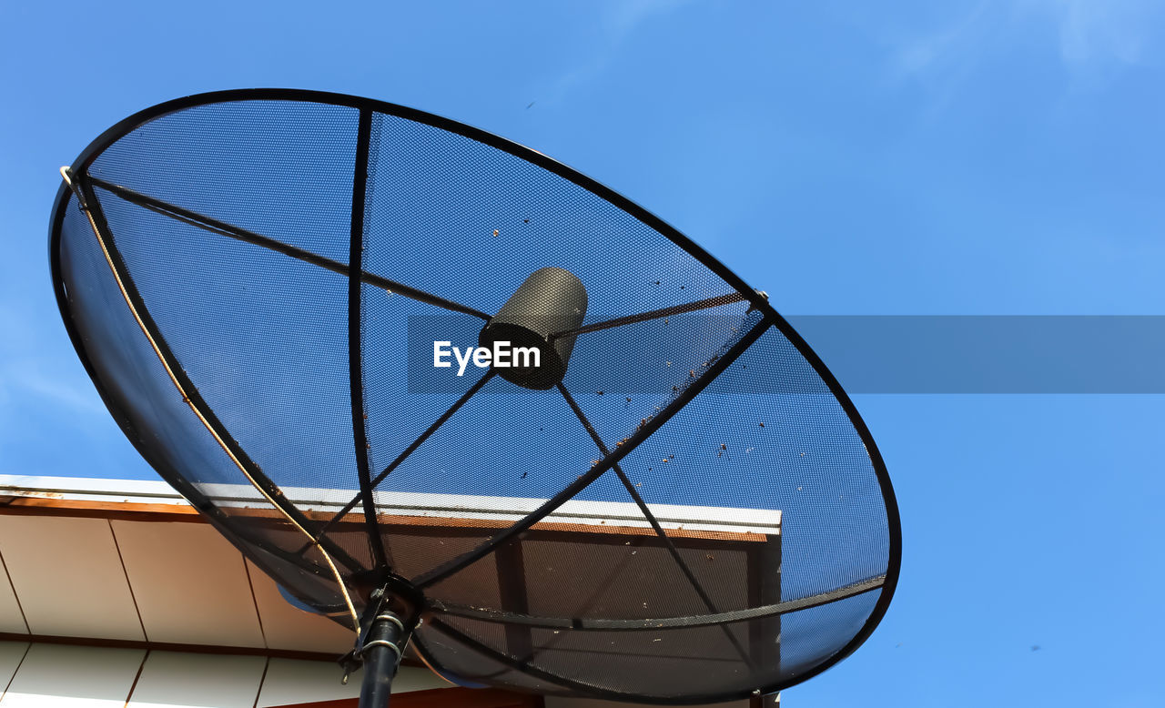 Low angle view of telephone pole against clear blue sky