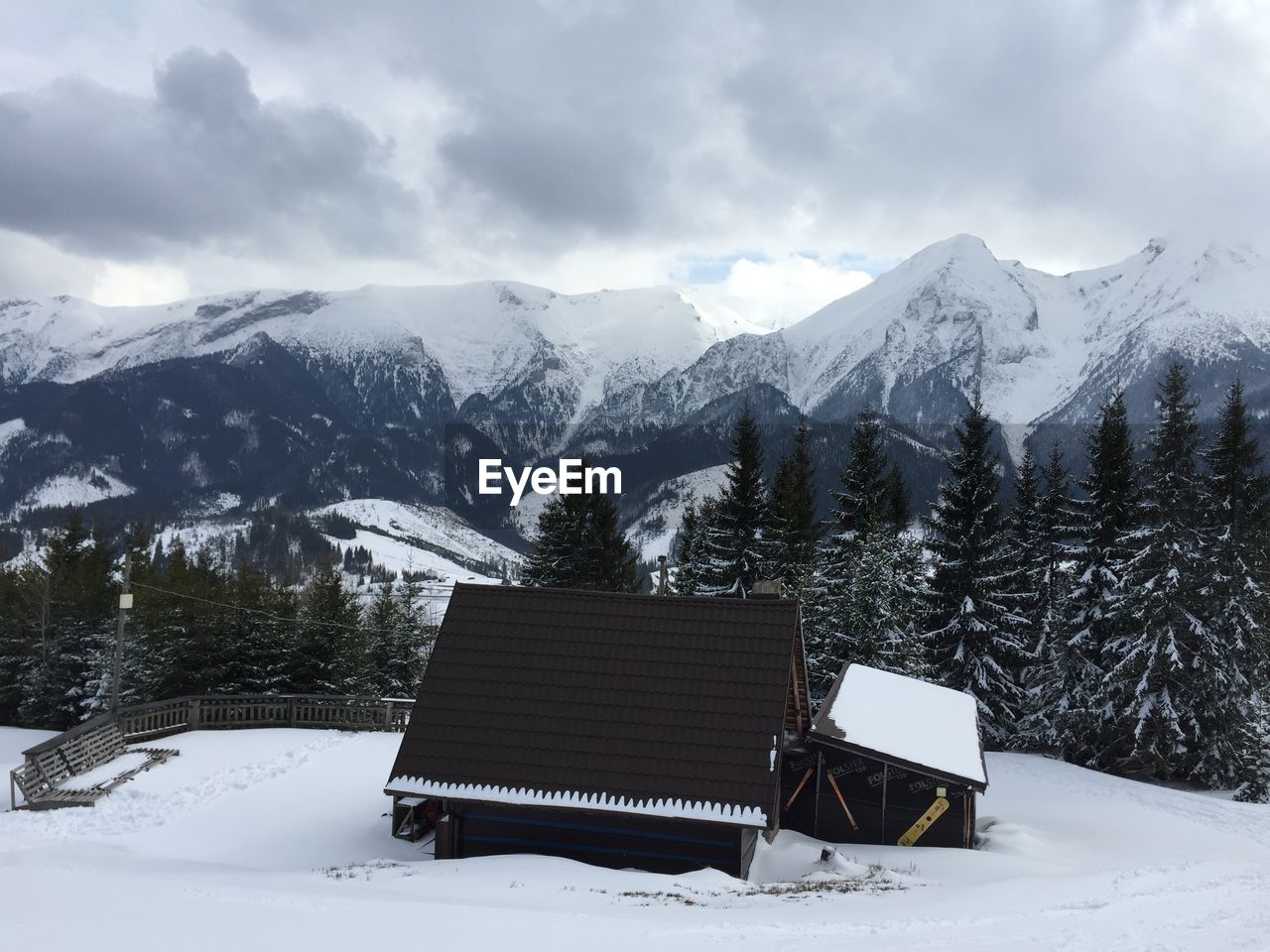 High angle view of house on snow covered field against mountains