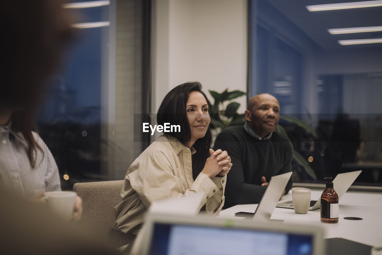 Businesswoman with male and female colleagues discussing in meeting at office