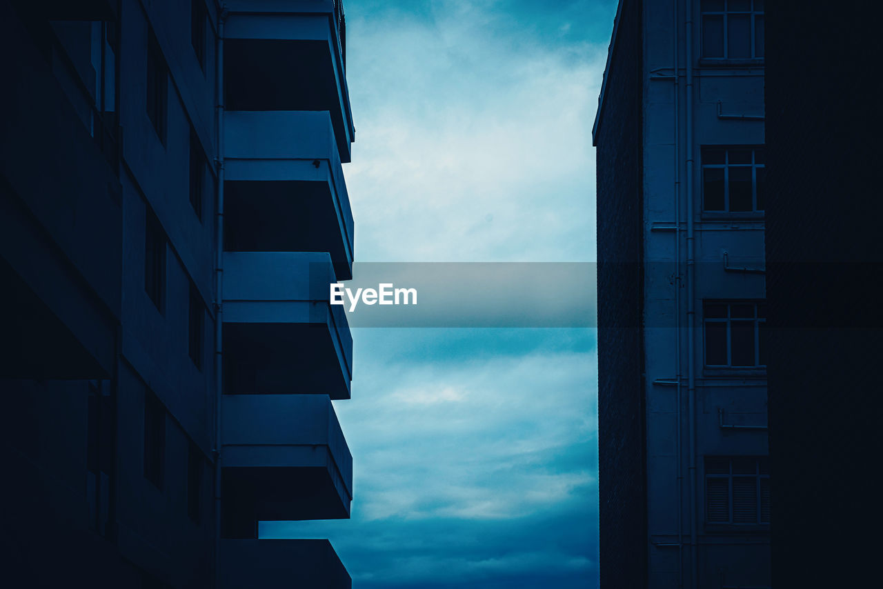 LOW ANGLE VIEW OF APARTMENT BUILDING AGAINST SKY