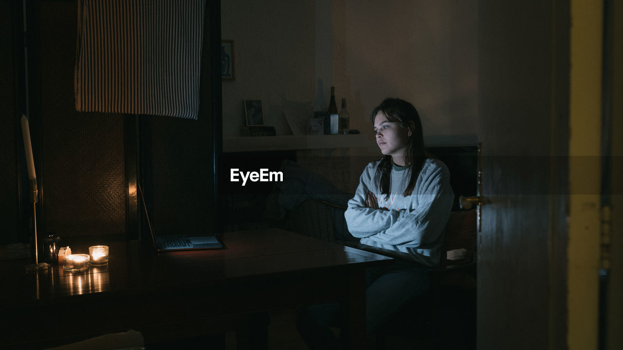 Young woman watching video over laptop on table at home