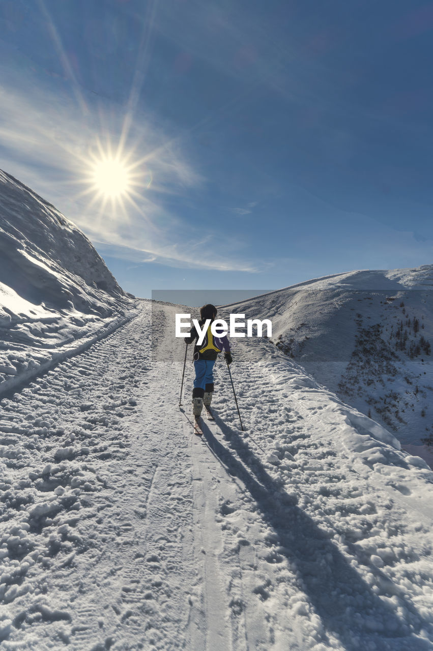 A child with mountaineering skis on a climb on italian alps