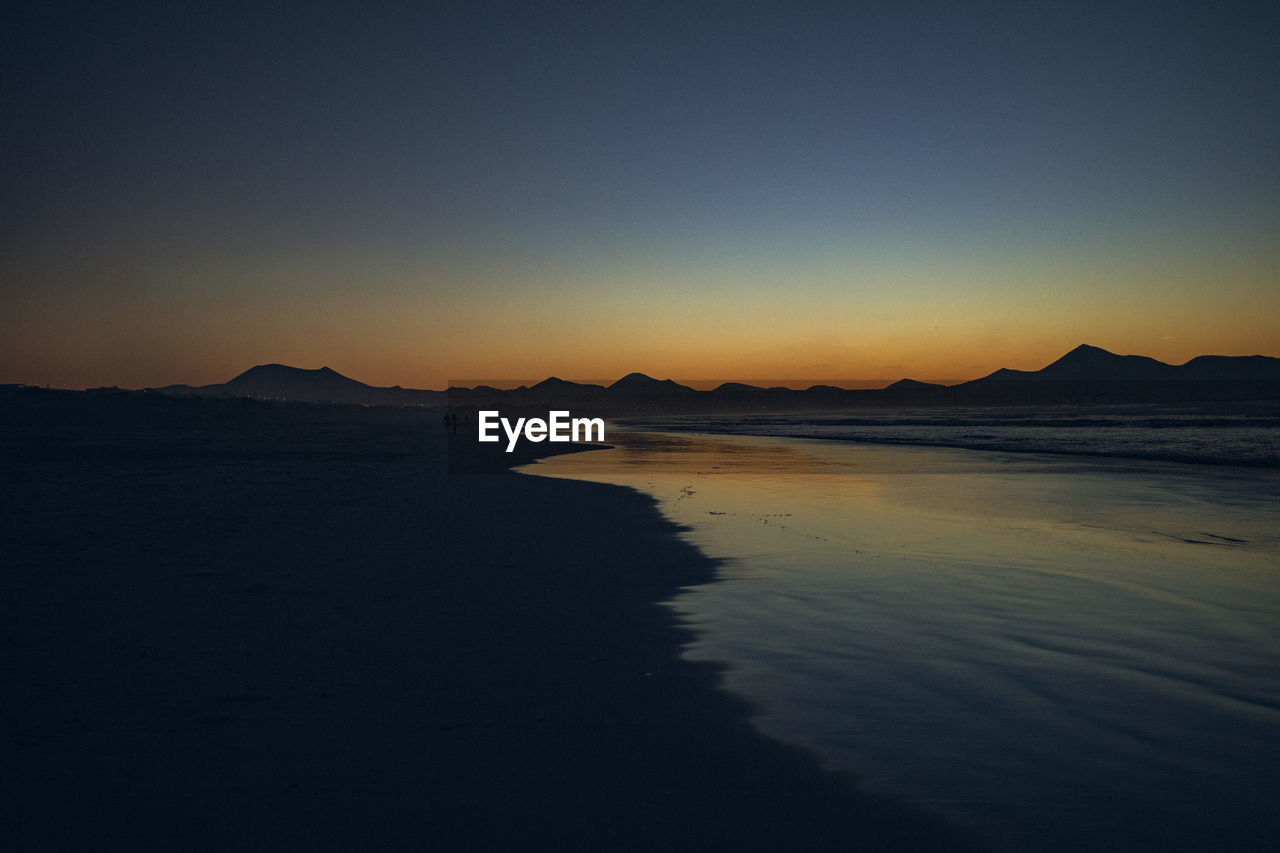 Scenic view of sea against clear sky during sunset