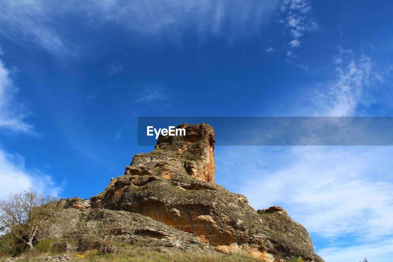 LOW ANGLE VIEW OF BLUE SKY AND CLOUDS IN SUNLIGHT