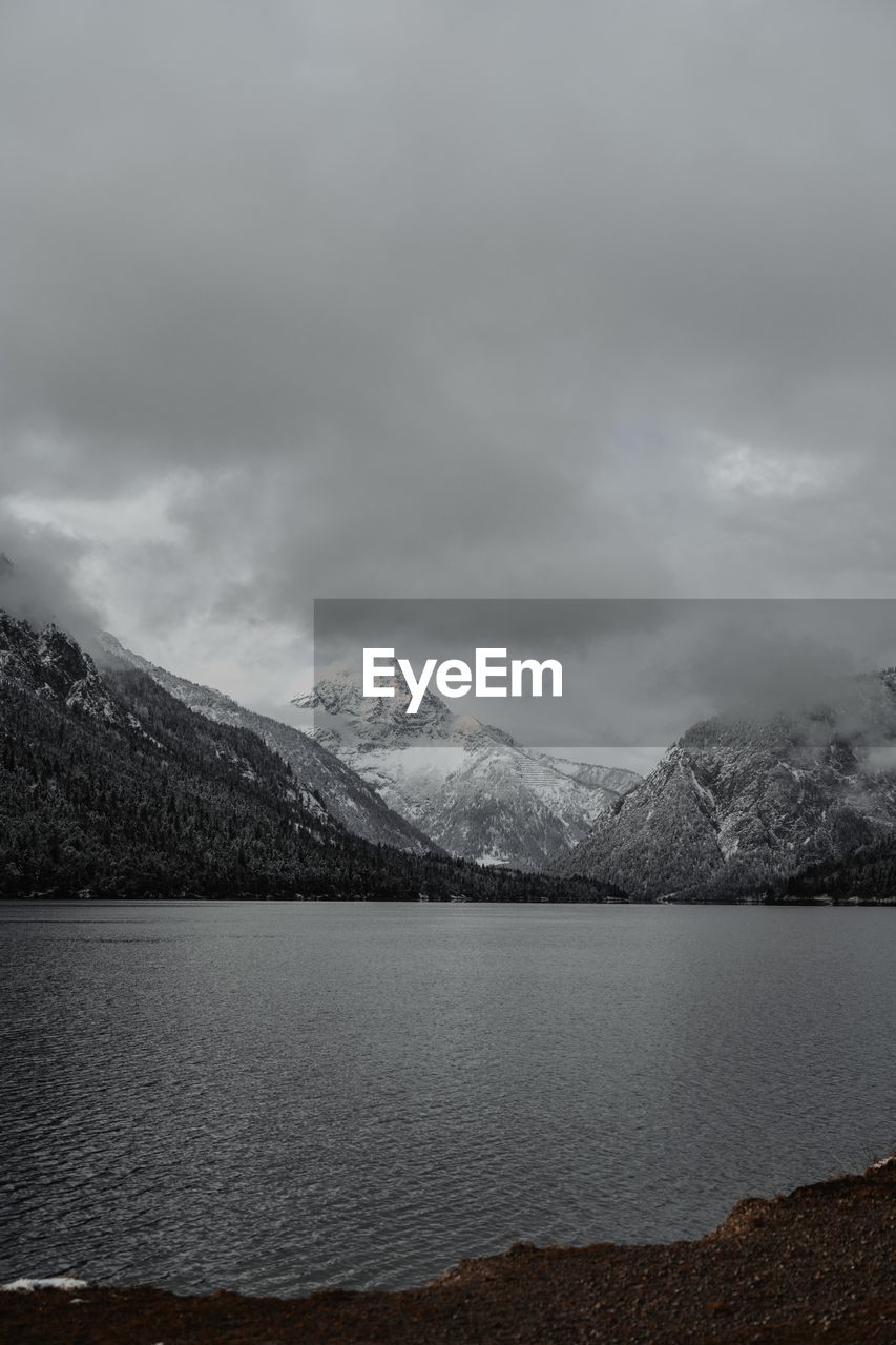 Scenic view of lake by mountains against sky