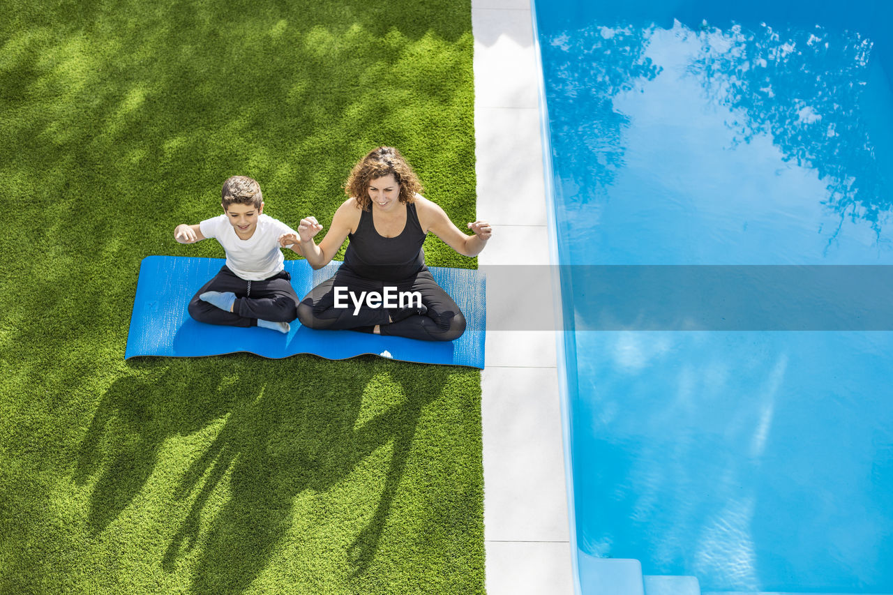 Mother and son doing yoga exercises in their home garden