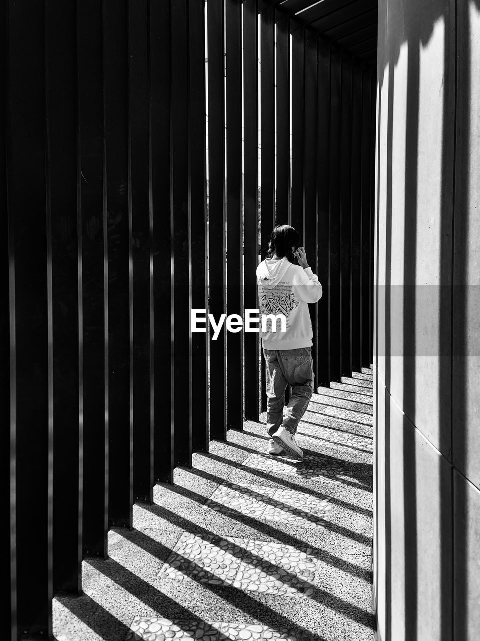 one person, architecture, black, full length, rear view, white, black and white, built structure, walking, lifestyles, day, men, leisure activity, monochrome, sunlight, shadow, monochrome photography, adult, casual clothing, women, staircase, standing, building, outdoors, line