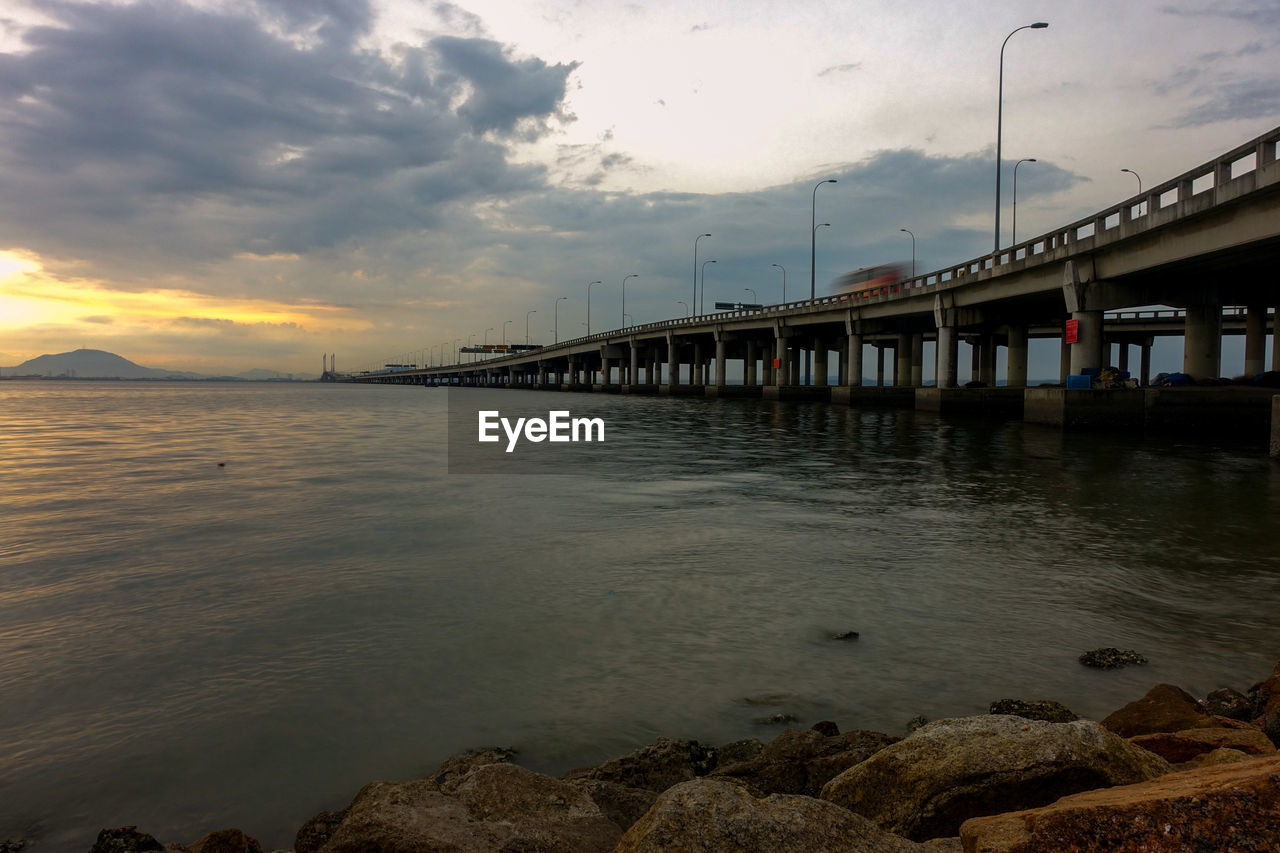 Pier over sea against sky during sunset