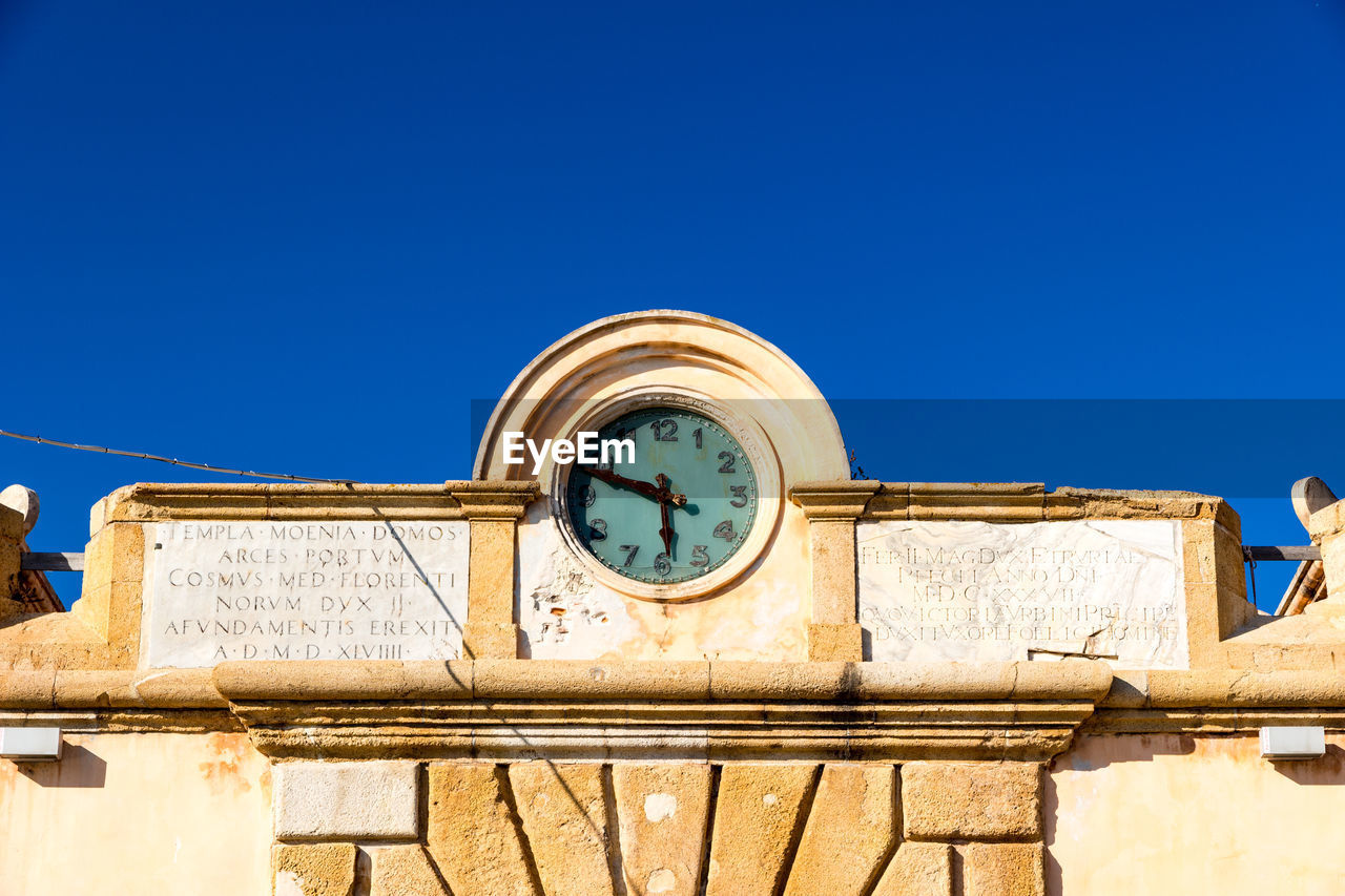 LOW ANGLE VIEW OF CLOCK AGAINST BLUE SKY AND BUILDING