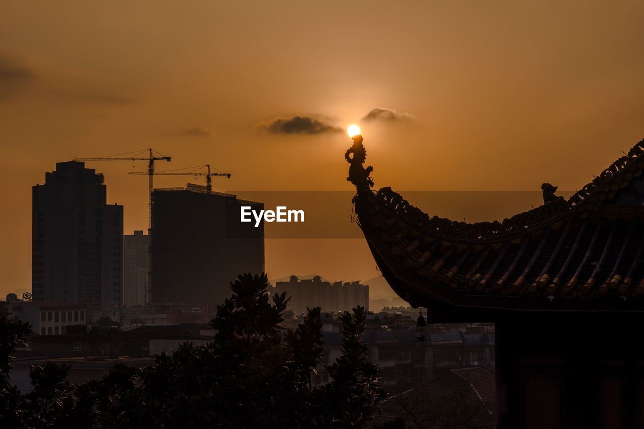 Silhouette roof of tianxin pavilion against sky during sunset