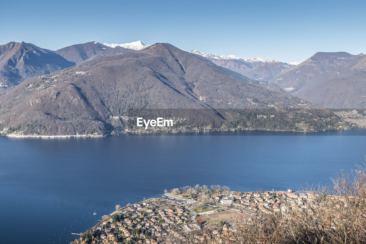 Scenic view of lake and mountains against clear blue sky