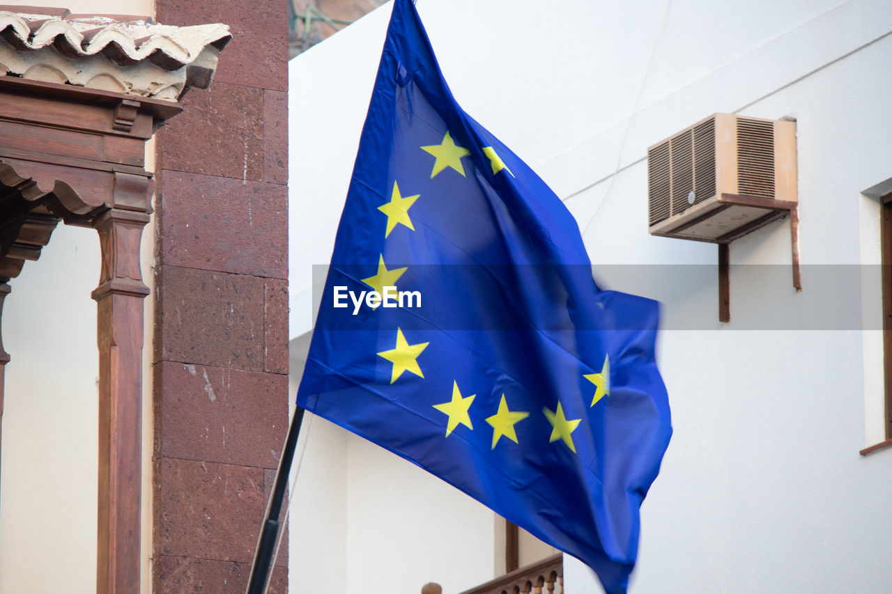 LOW ANGLE VIEW OF FLAGS AGAINST BUILDINGS