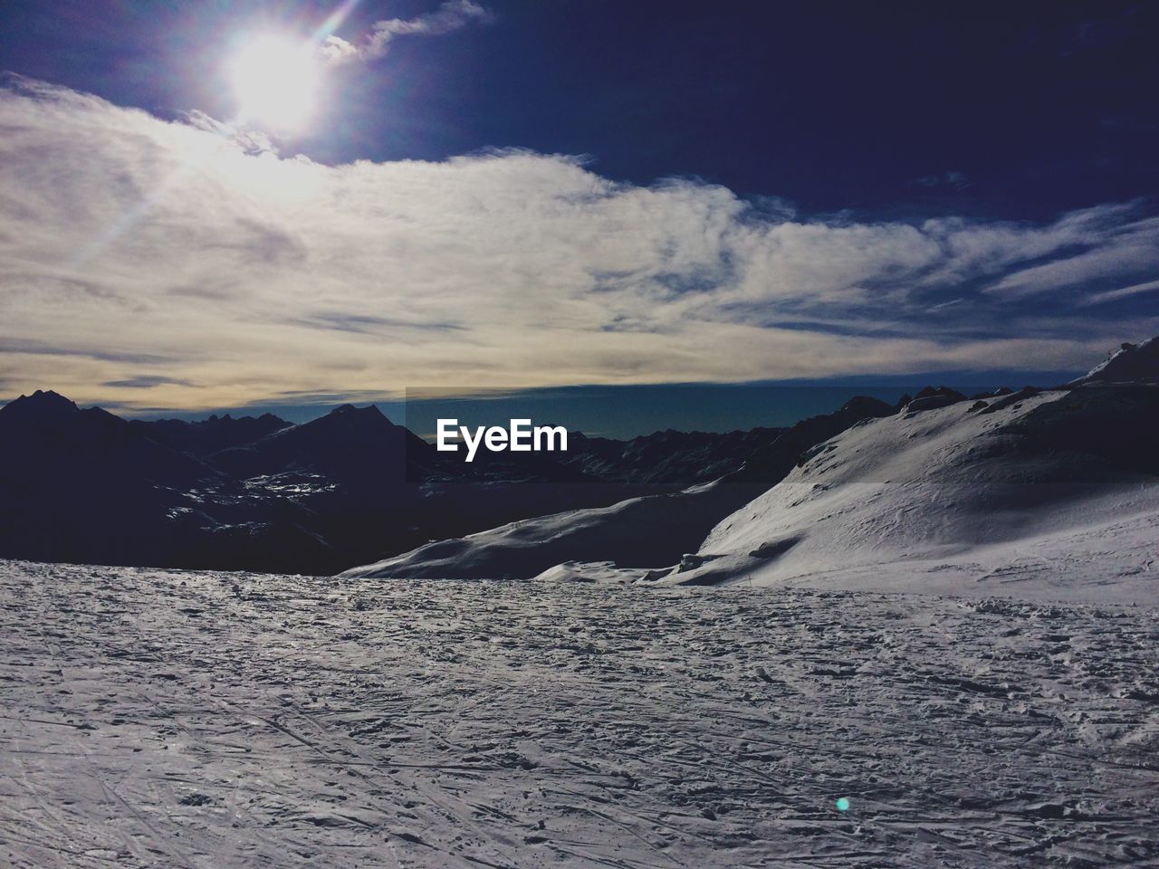 Scenic view of mountains against cloudy sky