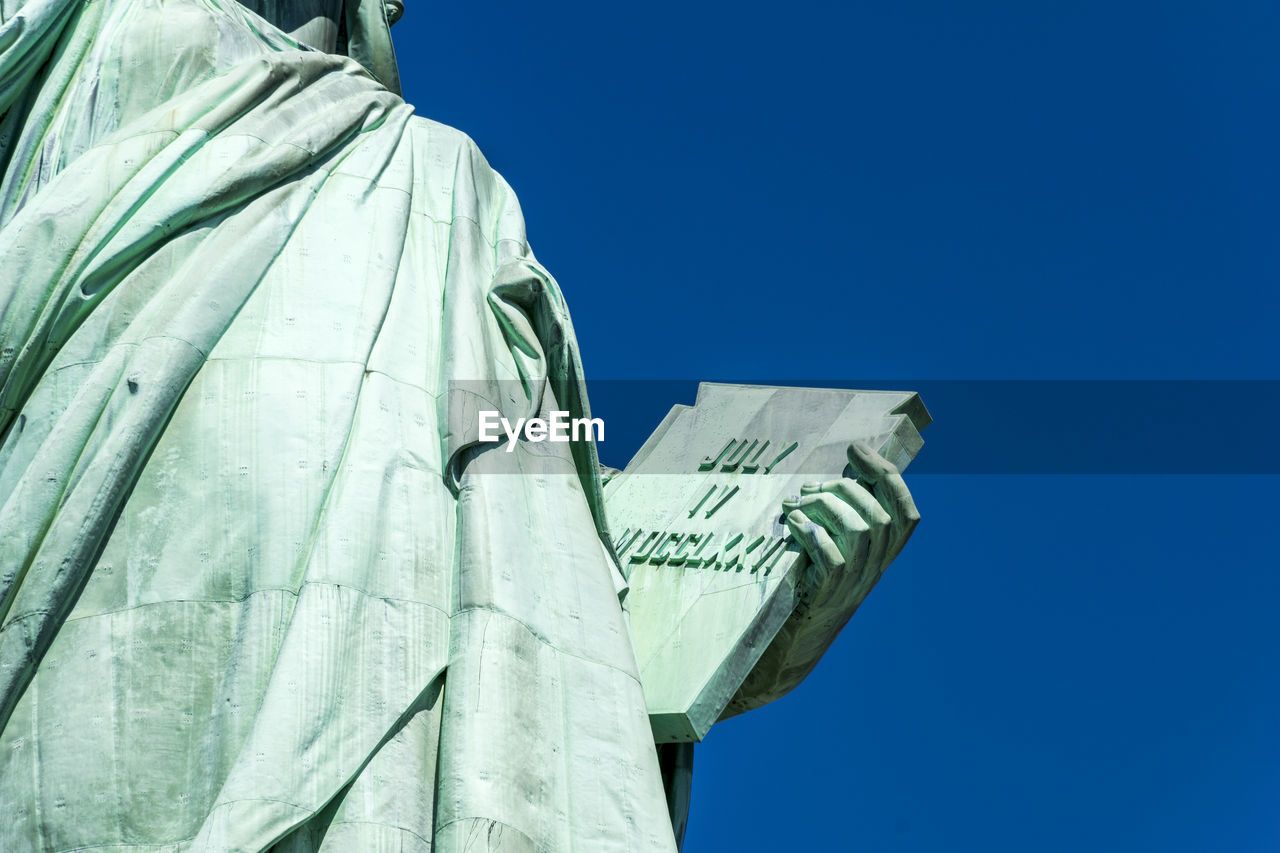 Low angle view of statue against clear blue sky