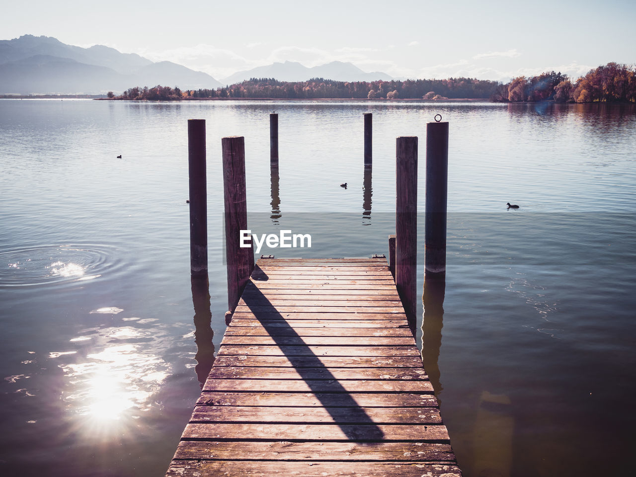 Wooden pier over lake against sky