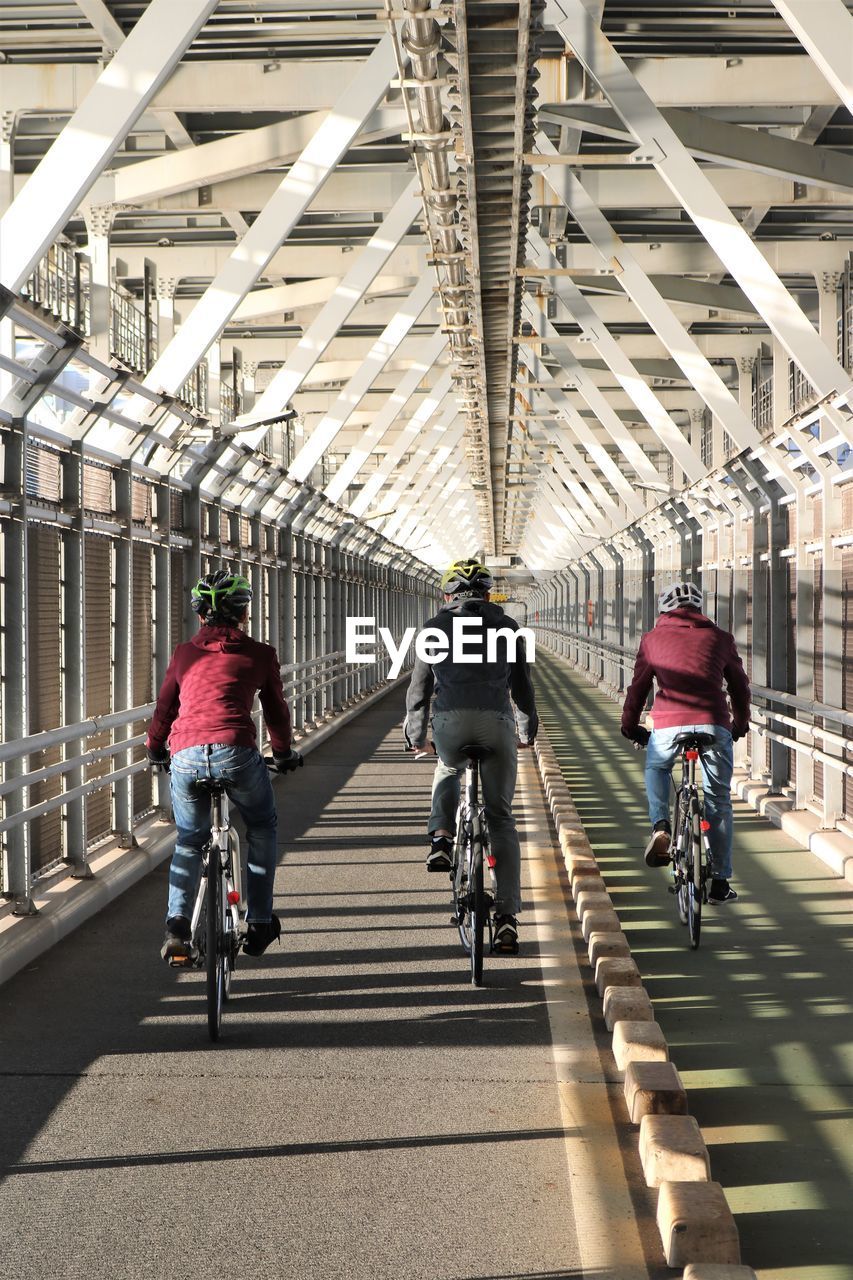 People riding bicycle on bridge