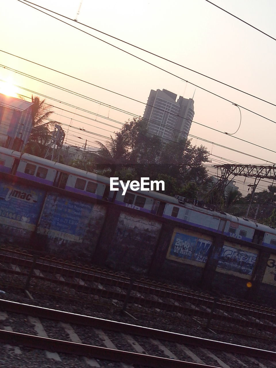 Railroad tracks against sky at sunset