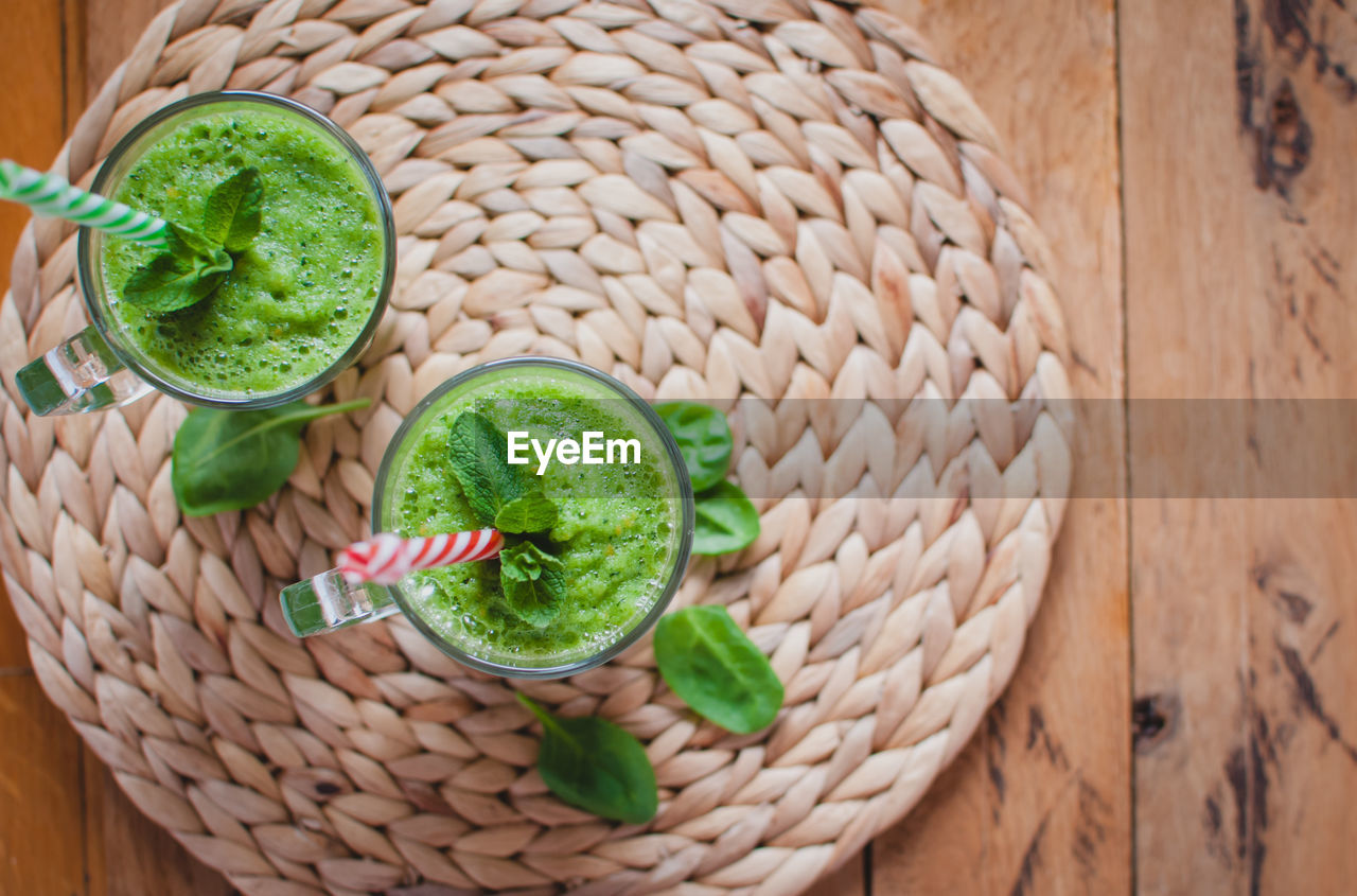 Close-up of green smoothie in a glass with fresh mint and ingredients, top view