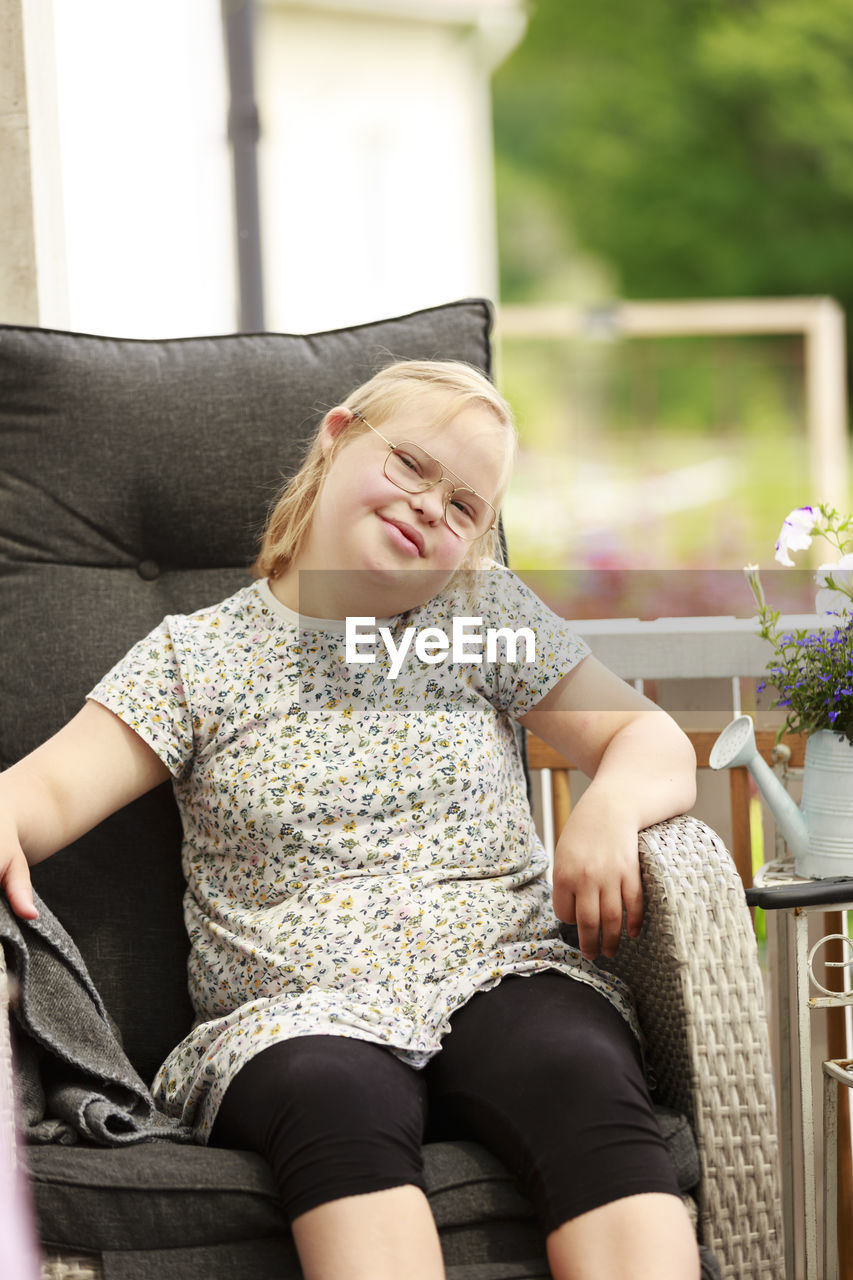 Portrait of girl sitting in armchair