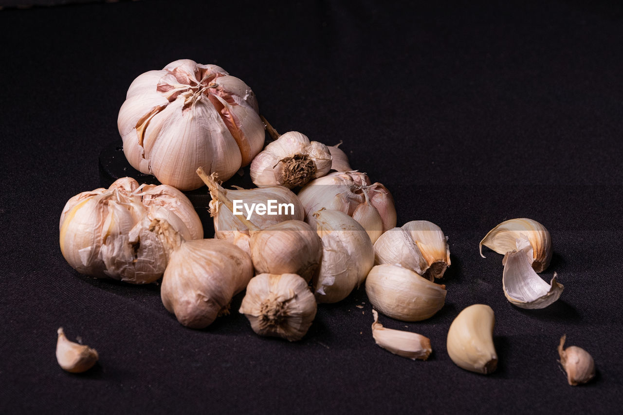 Close-up of garlic on table against black background