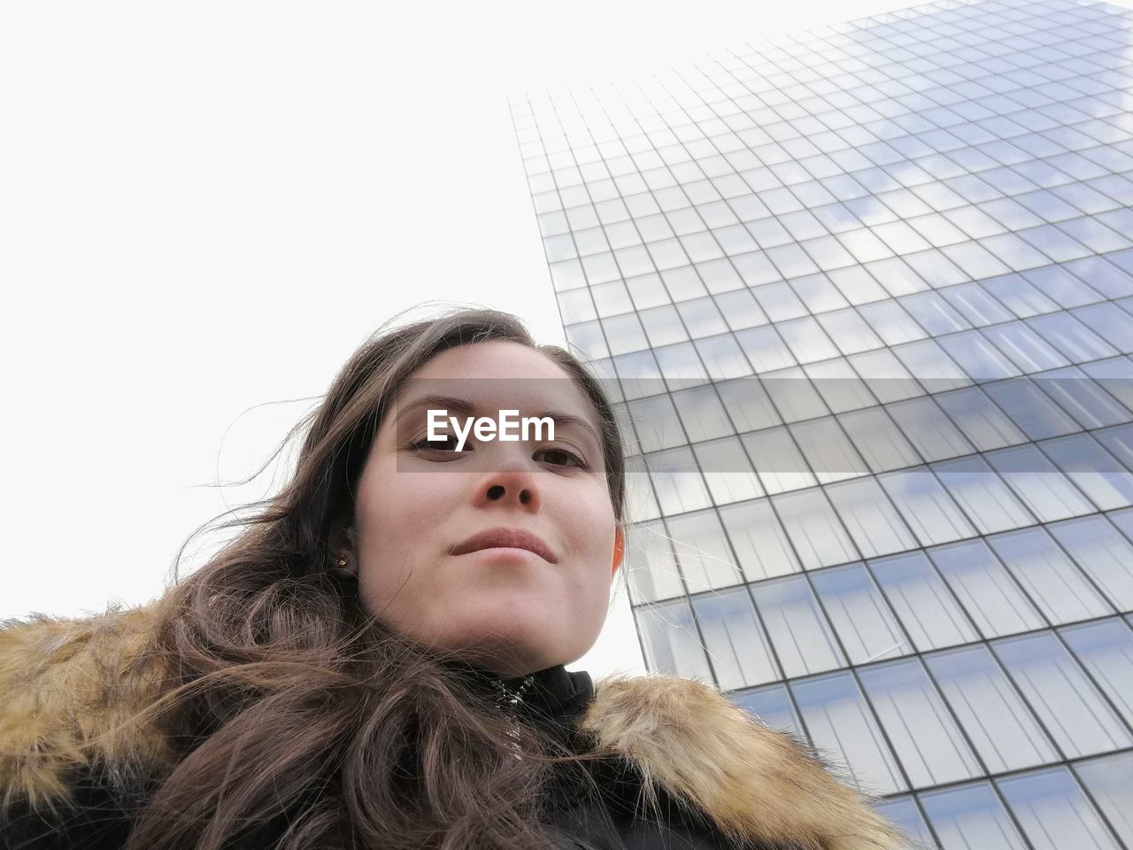 Portrait of beautiful young woman against sky