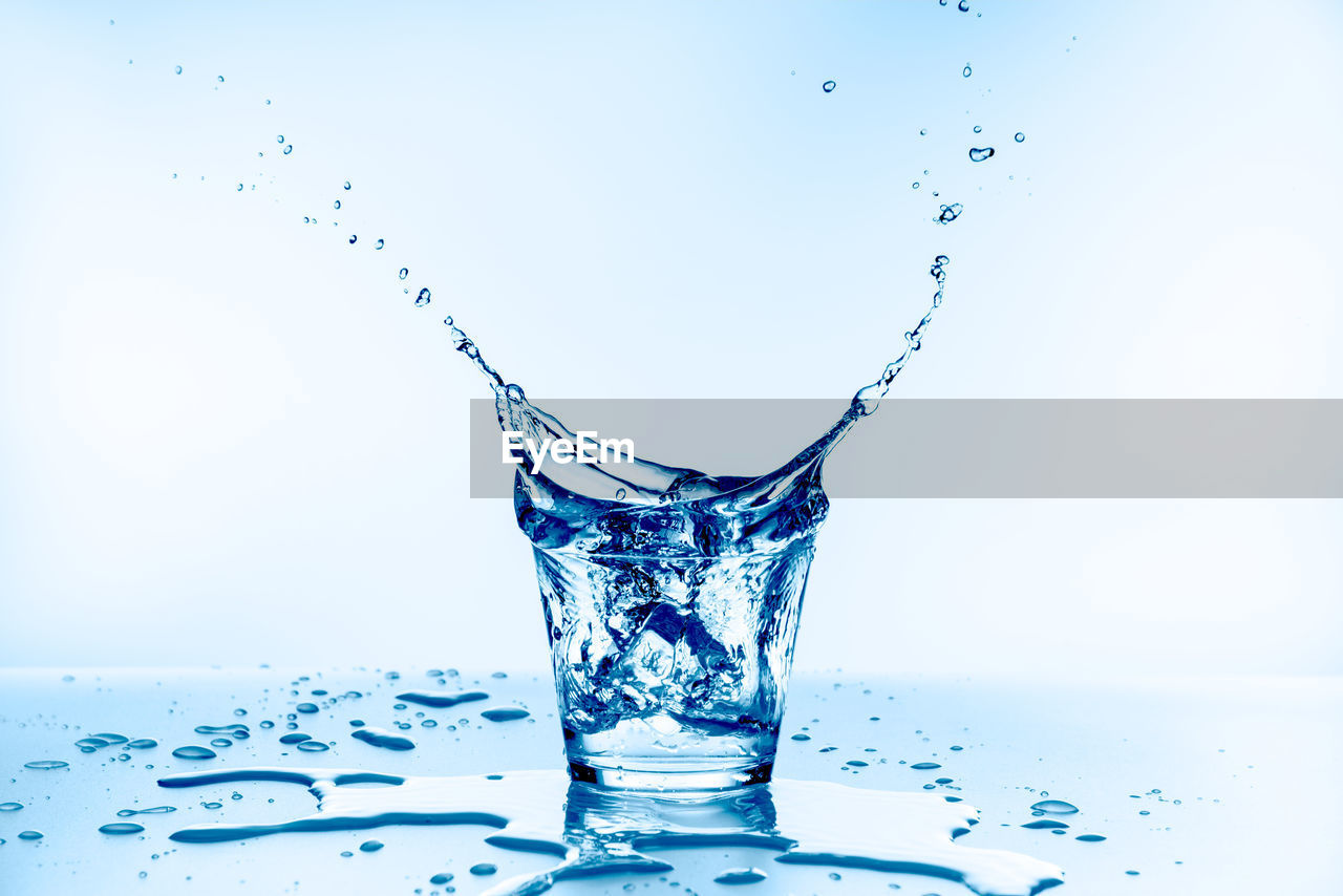 CLOSE-UP OF WATER SPLASHING ON GLASS