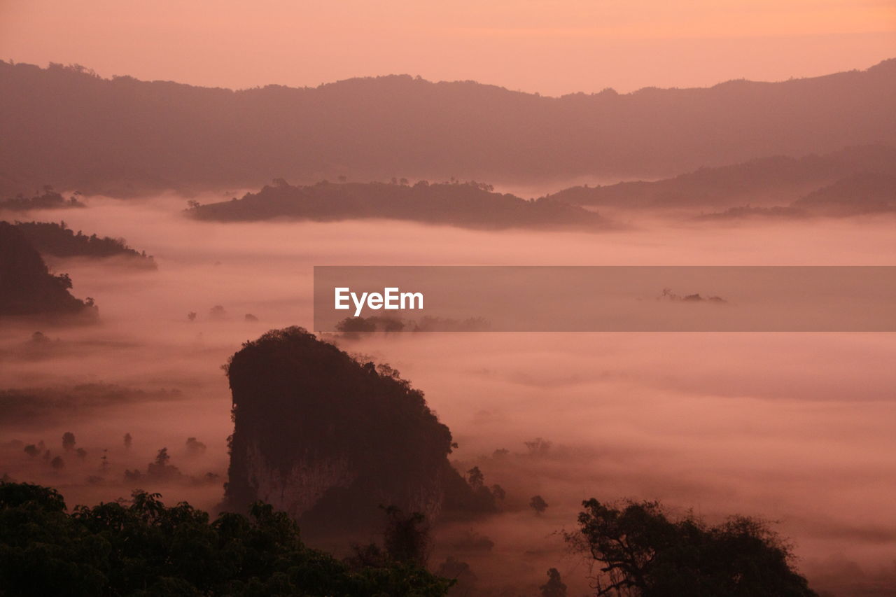 Scenic view of silhouette mountains against orange sky