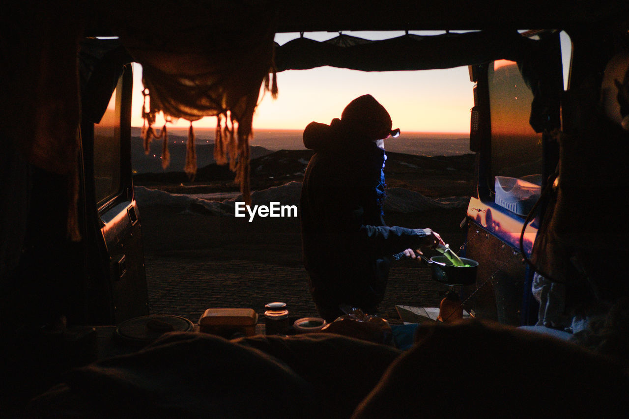 Woman sitting in tent against sky