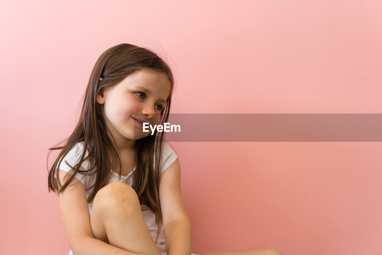 Smiling girl against colored background