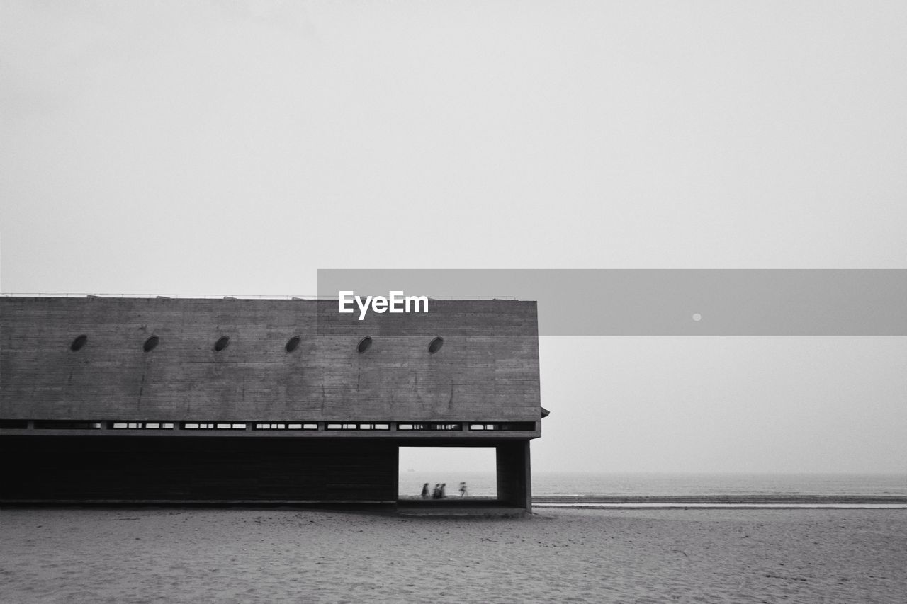 BUILT STRUCTURE ON BEACH AGAINST SKY