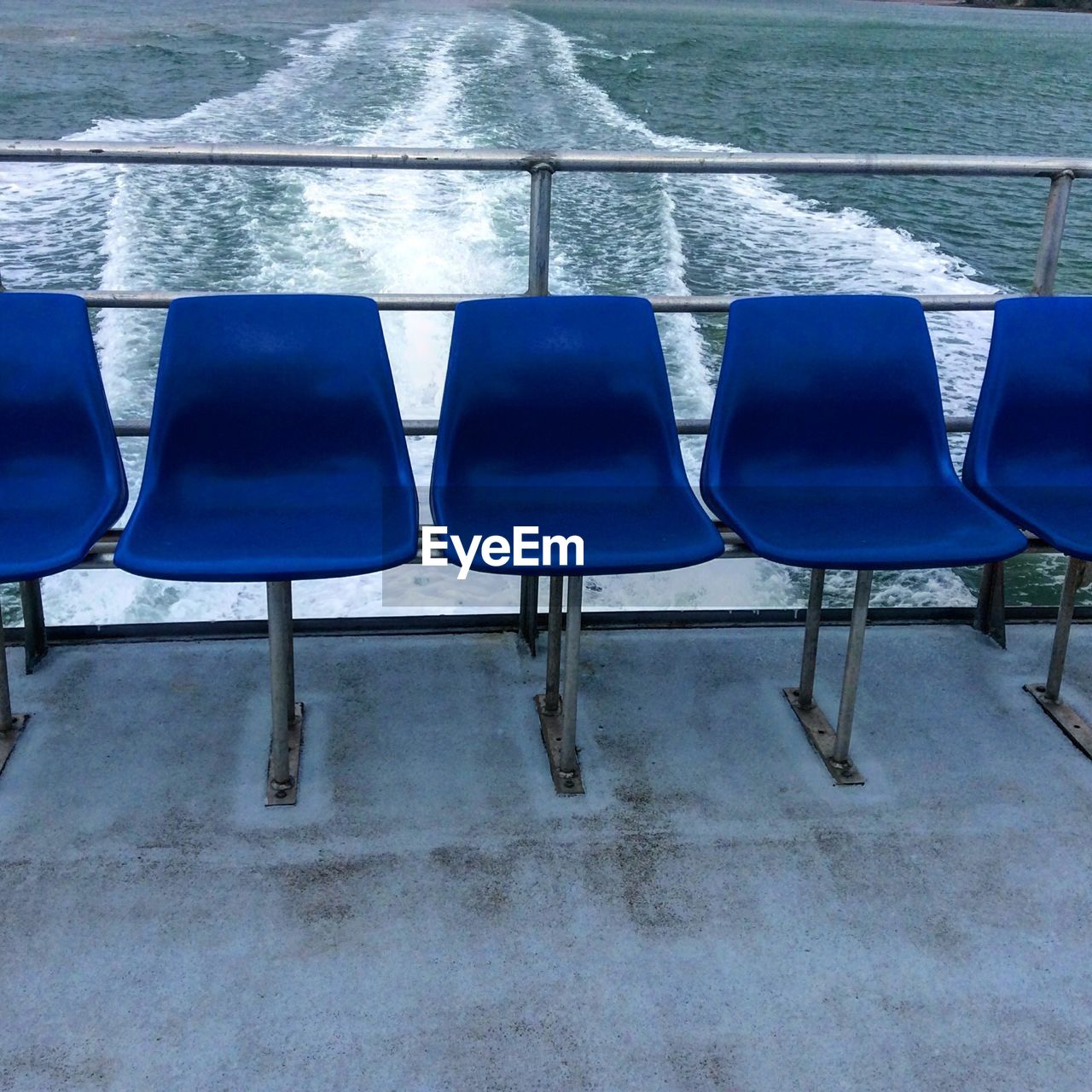 EMPTY CHAIRS ON SWIMMING POOL