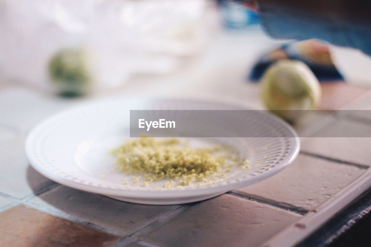 Lemon zest in plate on table