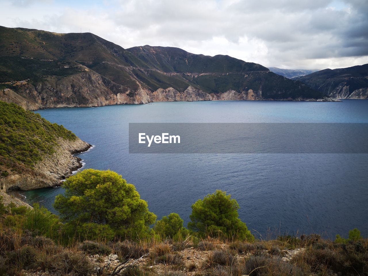 Scenic view of sea and mountains against sky