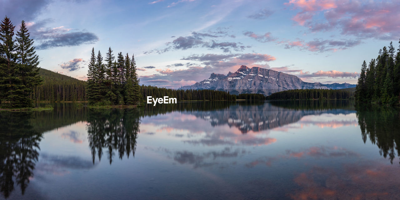 Scenic view of lake by trees against sky