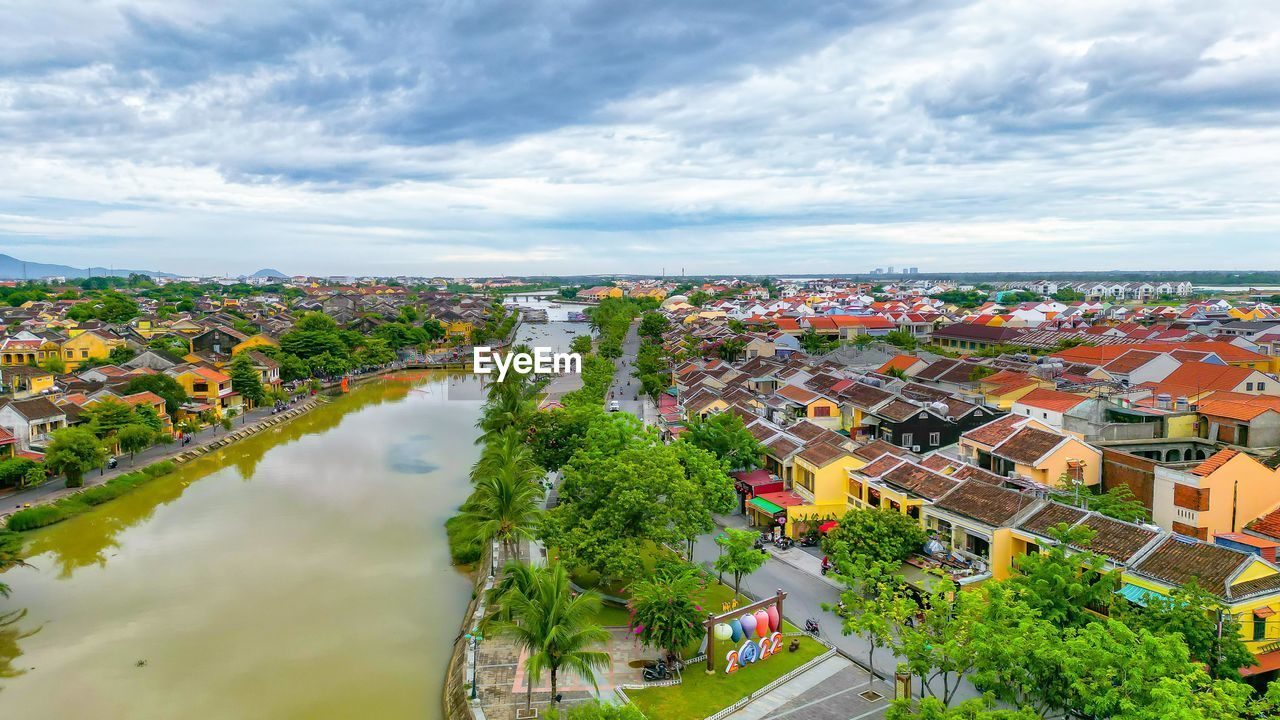 architecture, city, built structure, building exterior, water, building, sky, cloud, nature, aerial photography, cityscape, landscape, high angle view, environment, residential district, travel destinations, residential area, house, aerial view, bird's-eye view, travel, town, land, outdoors, no people, tourism, plant, scenics - nature, neighbourhood, tree, sea, transportation, urban skyline, roof, suburb, street, business finance and industry, day, summer, beauty in nature, horizon, urban design, construction industry, multi colored