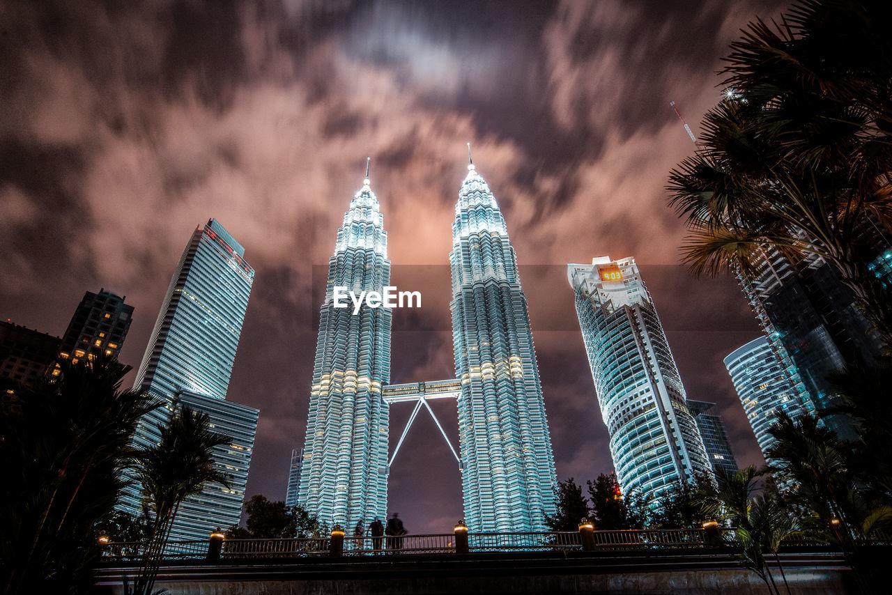 Low angle view of modern buildings against cloudy sky